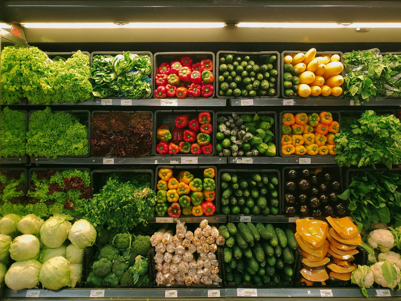Fresh vegetables and greens spilling from a paper grocery bag on a kitchen surface